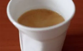 bílý šálek s kávou espresso na dřevěném povrchu