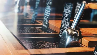 kavárenský pult s dřevěnými prvky a tabule s nápisy u baru