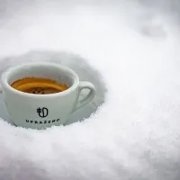 Šálek s logem UPRAZENO bílý keramický ve sněhu