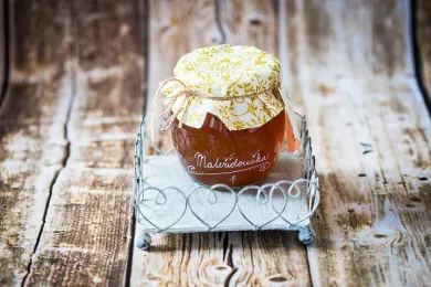 Bylinný sirup skleněná dóza s látkovým víčkem na kovovém stojánku se srdíčky na dřevěném stole