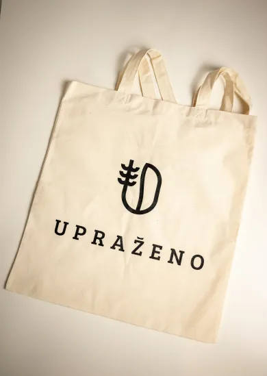 přírodní plátěná taška s černým logem a nápisem UPRAŽENO