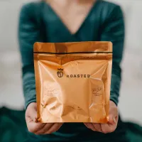 Obal zrnkové kávy Roasted oranžová kovová folie s nápisem ROASTED