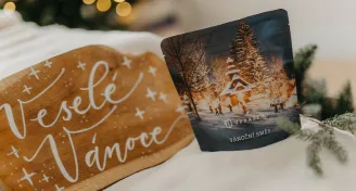 Veselé Vánoce na dřevěné desce vedle vánočního sáčku